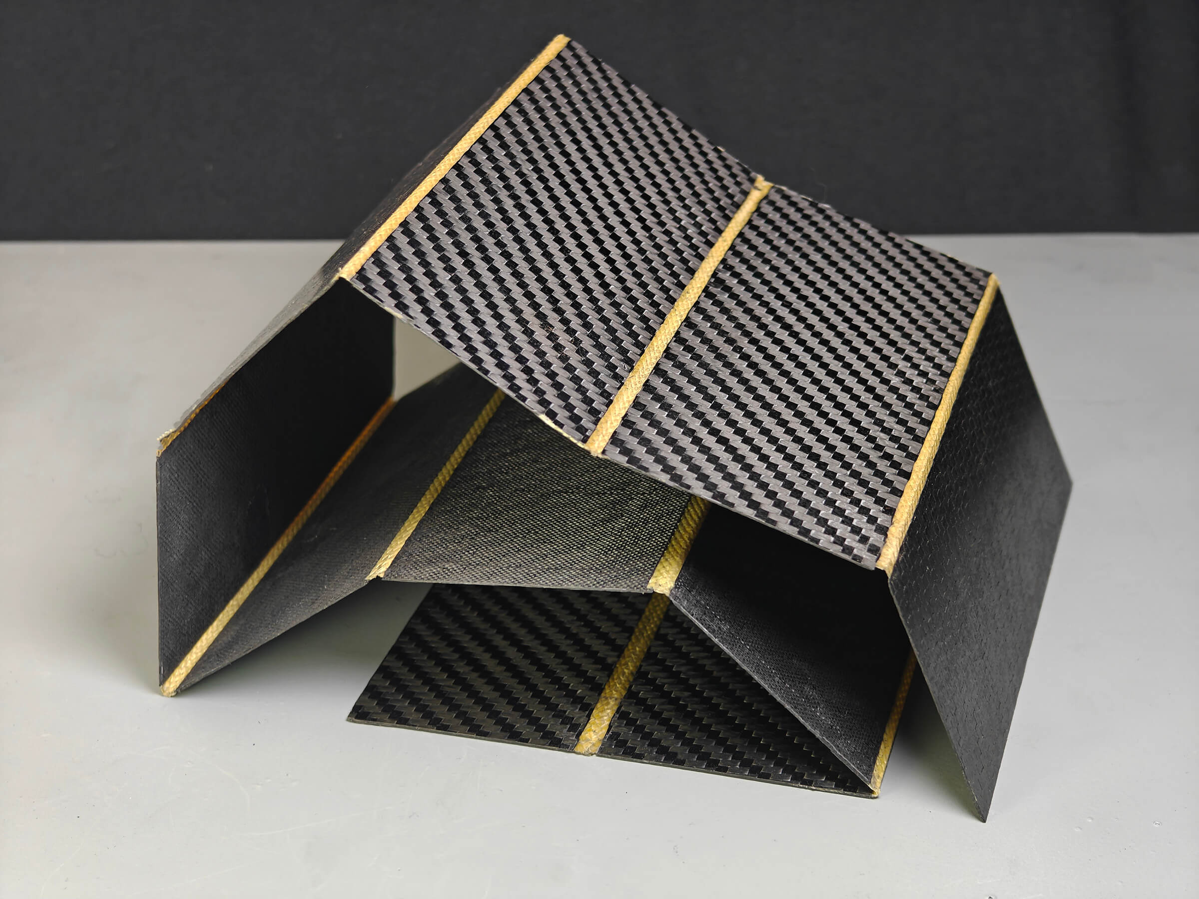 Multi-panel carbon fibre sheet joined by Carbon Hinge flex lines, partly folded